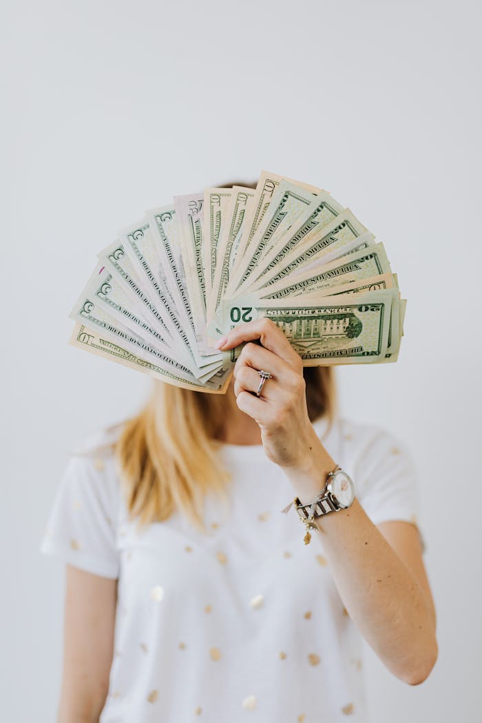 Woman Holding Fan of Us Dollar Bills